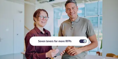 Two smiling colleagues holding a tablet in a bright, modern office, with the title 